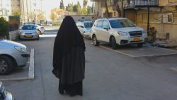 אישה מכוסה צועדת ברחוב